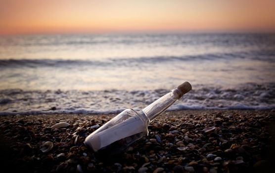 letter in a bottle on the beach at sunset