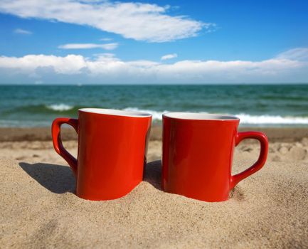 two red cups on a sunny beach