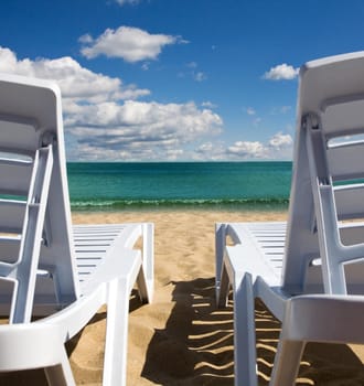 An attractive image of two chairs on the beach