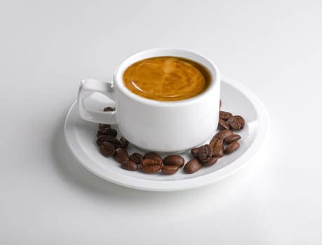 Cup of coffee on white with coffee beans