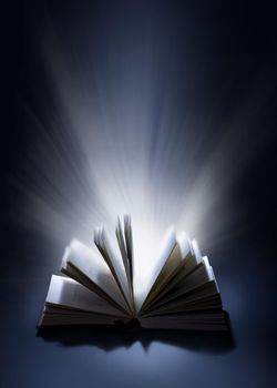 Opened magic book with magic light