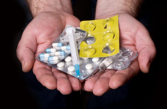 hands holding the drugs on a dark background