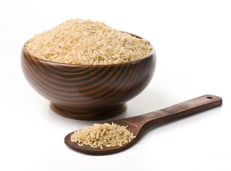 wooden cup with uncooked rice on a white background