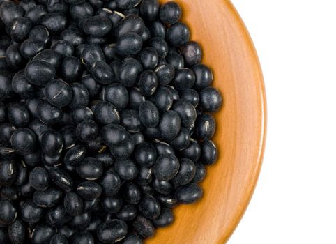 Black soybeans close up in a wooden tray