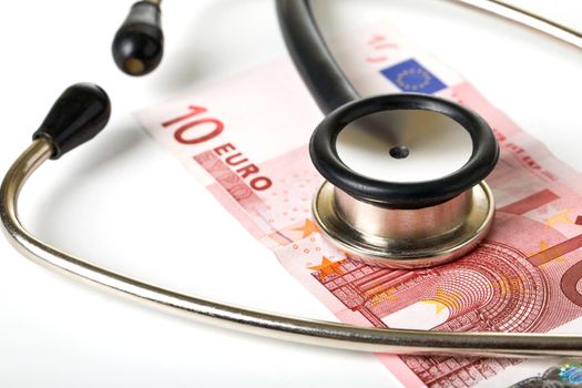 Medical stethoscope and monetary denominations of euro, close up