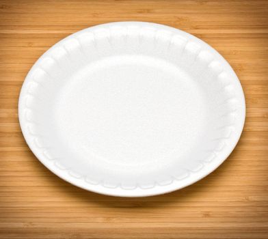 white disposable plates on a wooden table