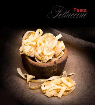 Italian pasta fettuccine nest  on dark  background