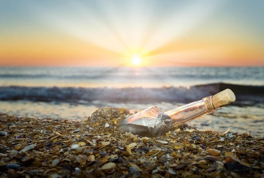 letter in a bottle on the beach at sunset