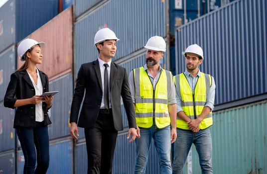 Group of cargo container workers or factory and engineer technicians walk and discuss together in workplace area. Concept of good teamwork support best success work of industrial business.