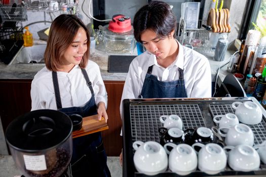 Top view of two barista or coffee maker work in front the machine with happy emotion. Happy working with small business and sustainable concept.