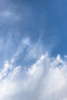 Blue sky background with scattered white clouds.