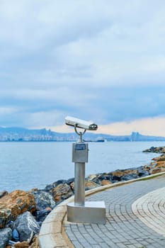 Tourist sightseeing binoculars on the promenade of Buyukada island overlooking Istanbul.