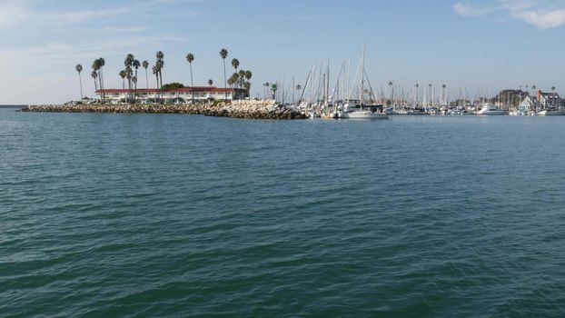 View of sea water from sailing boat or yacht, Oceanside harbor, summer vacations in California USA. Seascape from sailboat in port, tropical marina harbour. Pacific ocean coast, whale watching tour.