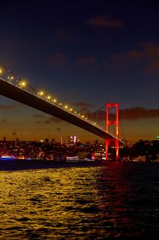 Evening boat trip on the Bosphorus in Istanbul. Bosphorus Bridge, in the night lights.