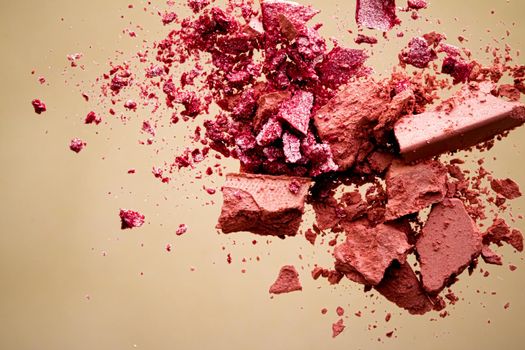 Crushed cosmetics, mineral organic eyeshadow, blush and cosmetic powder isolated on golden background, makeup and beauty banner, flatlay design.