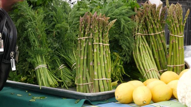 Organic vegetables on counter, fresh local produce homegrown raw veggies on marketplace stall. Healthy vegetarian food, Farmers market in Oceanside California USA. Agricultural farm harvest selling.