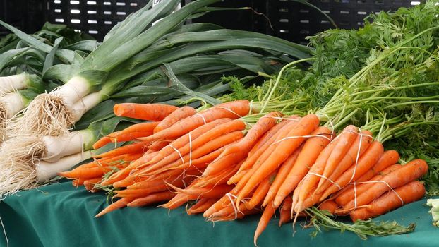 Organic vegetables on counter, fresh local produce homegrown raw veggies on marketplace stall. Healthy vegetarian food, Farmers market in Oceanside California USA. Agricultural farm harvest selling.