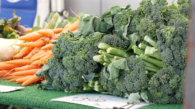 Organic vegetables on counter, fresh local produce homegrown raw veggies on marketplace stall. Healthy vegetarian food, Farmers market in Oceanside California USA. Agricultural farm harvest selling.