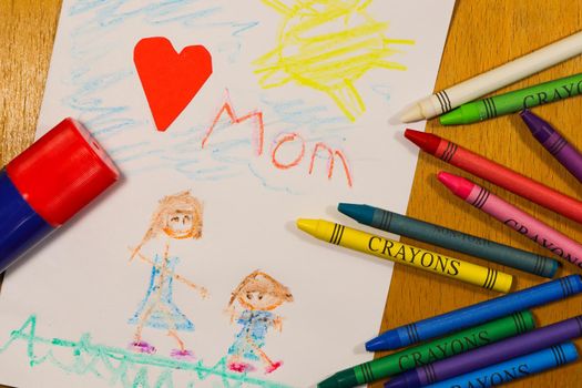 Child's colorful gift card crayon drawing to Mom with crayons and glue stick