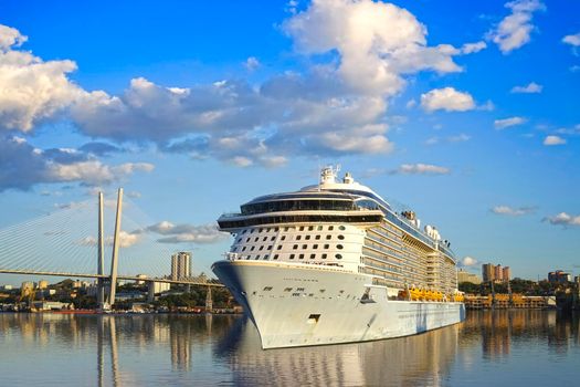Vladivostok, Primorsky Krai-Sseascape with a beautiful cruise ship on the background of the city. In the background, the landmark Golden bridge.