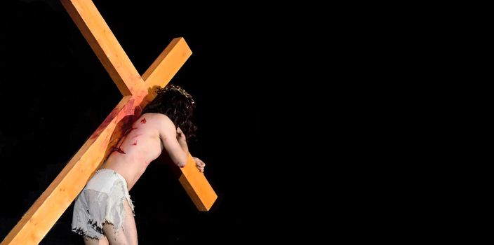 Jesus carrying the Cross into the darkness.Crucifixion of Jesus.Easter Religious concept.