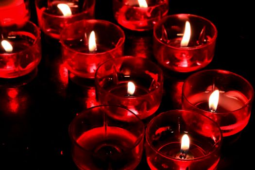 Texture of red candles lit by prayers in a church of Lisbon