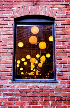 Round white lamps seen through a window.