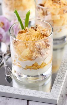 Chicken salad with pineapple, corn, seasoned with Greek yogurt, crushed nuts and grated cheese. A salad in a glass, a great idea for serving food in portions.