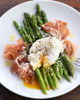 Eggs Benedict with parmesan, green asparagus and Parma ham