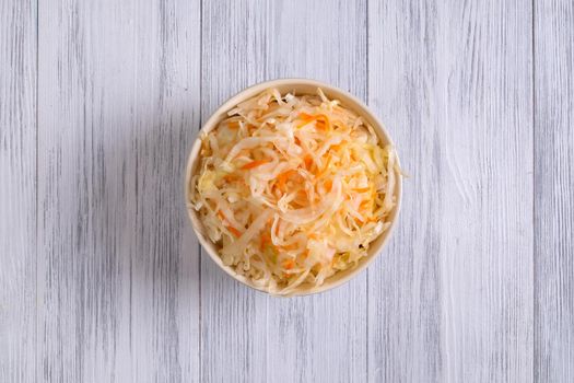 Top view of a ceramic bowl with fermented sauerkraut. Healthy food concept. Selective focus.