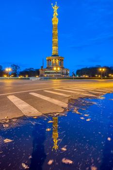 The famous Victory Column in the Tiergarten in Berlin, Germany, at dusk, with a reflection in a puddle