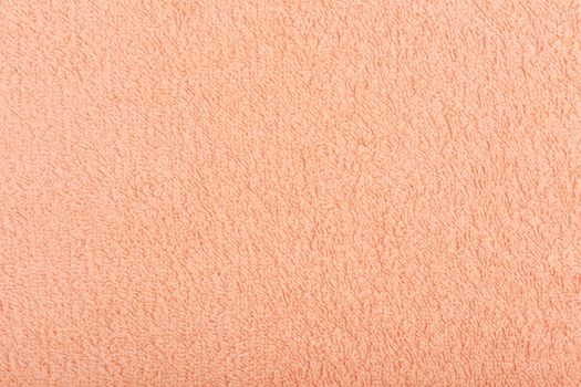 Orange fuzzy towel background. Fleecy fabric close up with space for text. Cozy material for bathroom towels or bathrobe