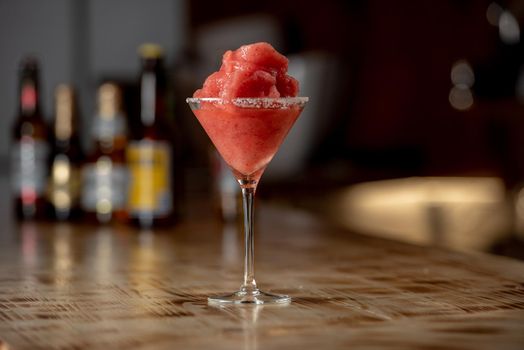 Frozen margarita cocktail on wooden bar.