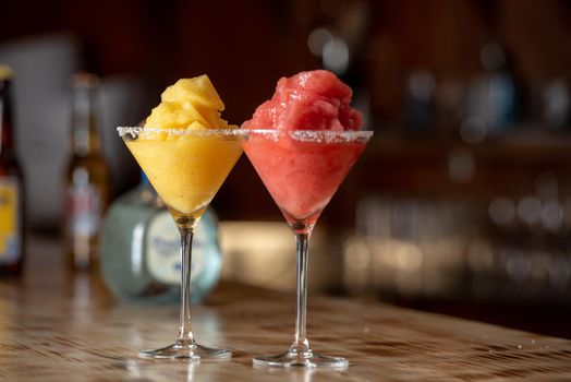 Frozen margarita cocktail on wooden bar.