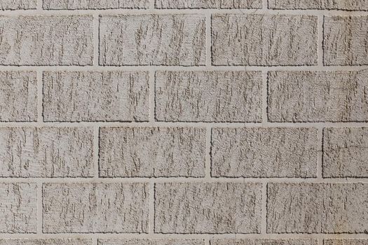 artificial brick-like pattern embossed in flat plaster surface.