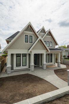 Luxurious residential house without green lawn on the front yard. Brand new North American family house for sale