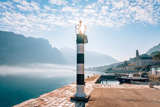 Black and white lighthouse in the sea. Prcanj, Kotor Bay, Montenegro.