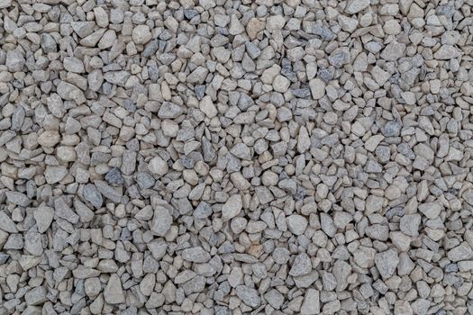 Dry white limestone ballast flat full frame background. Small gray dusty broken macadam stones texture. Viiew from above.