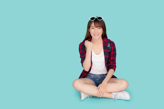 Beautiful portrait young asian woman wear sunglasses on head smile excited summer holiday isolated blue background, asia girl sitting cheerful while vacation trip, travel concept.