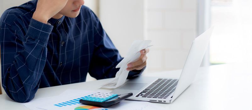 Young asian man calculating expenses household about finance and frustrated on desk at home, male checking bill having stress and worried, debt and tax, expression and emotion, business concept.