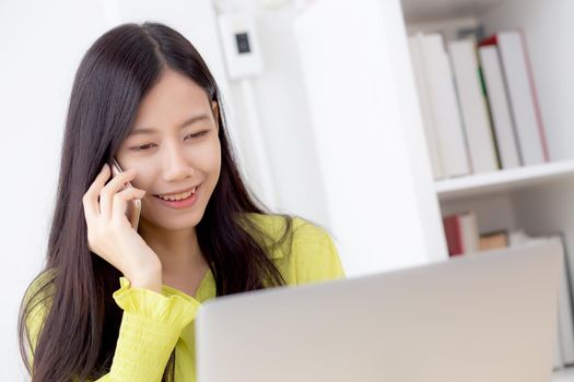 Young asian business woman working form home office and call phone for success at home, businesswoman using laptop computer on desk, female talking smartphone at workplace, communication concept.