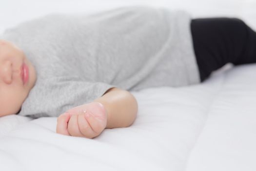 Portrait of asian little baby girl sleeping on bed in the bedroom at home, newborn napping with cozy and relax, infant innocence in bedtime, happy toddler cute, growth of child and emotion, indoors.