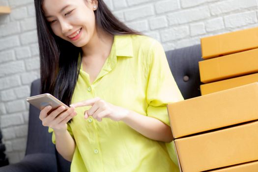 Young asian woman is entrepreneur check order from smartphone with customer while purchase online, logistic and delivery, online shopping, female is seller of business SME, merchant looking phone.