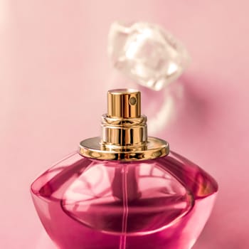 Perfumery, spa and branding concept - Pink perfume bottle on glossy background, sweet floral scent, glamour fragrance and eau de parfum as holiday gift and luxury beauty cosmetics brand design