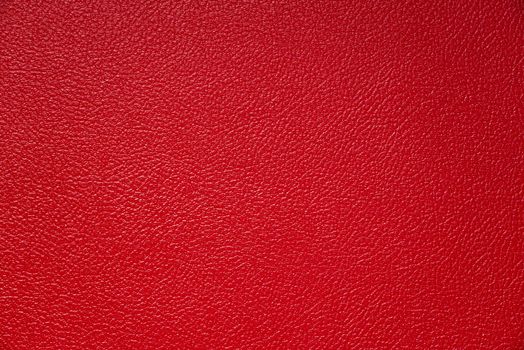 The subtle texture of red tolex on a guitar amp speaker cabinet. The vinyl covering protects the surface.