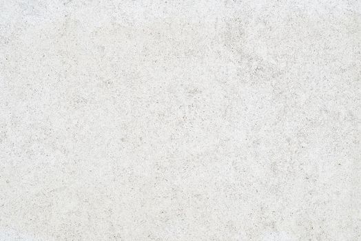 The subtle white textured surface of an external concrete wall. The wall is lightly speckled.