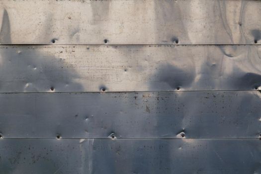 horizontal shiny stainless steel sheets nailed to flat surface - flat background and texture