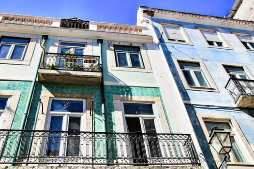 Old colorful and majestic tiled facades with vintage streetlight in Lisbon streets in Spring.