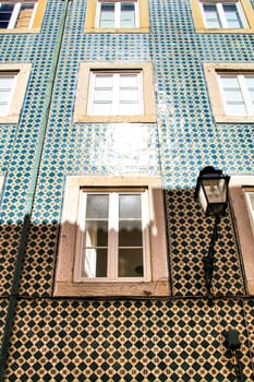 Old colorful and majestic tiled facades with vintage streetlight in Lisbon streets in Spring.