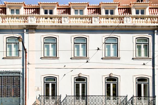 Old colorful and majestic tiled facades with vintage streetlight in Lisbon streets in Spring.